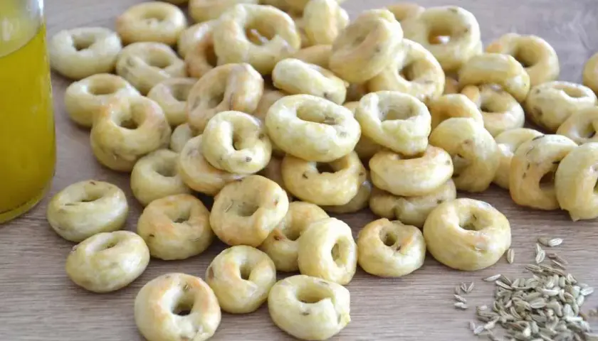 Taralli pugliesi ricetta originale: tanti piccoli anelli dorati, croccanti e profumati, pronti per essere gustati.