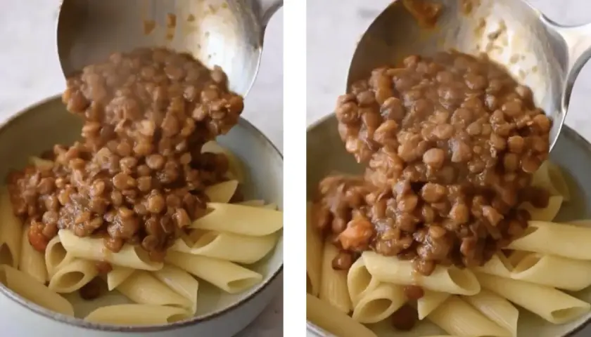 Un mestolo versa un saporito ragù di lenticchie su penne al dente. Un piatto vegetariano invitante e nutriente.