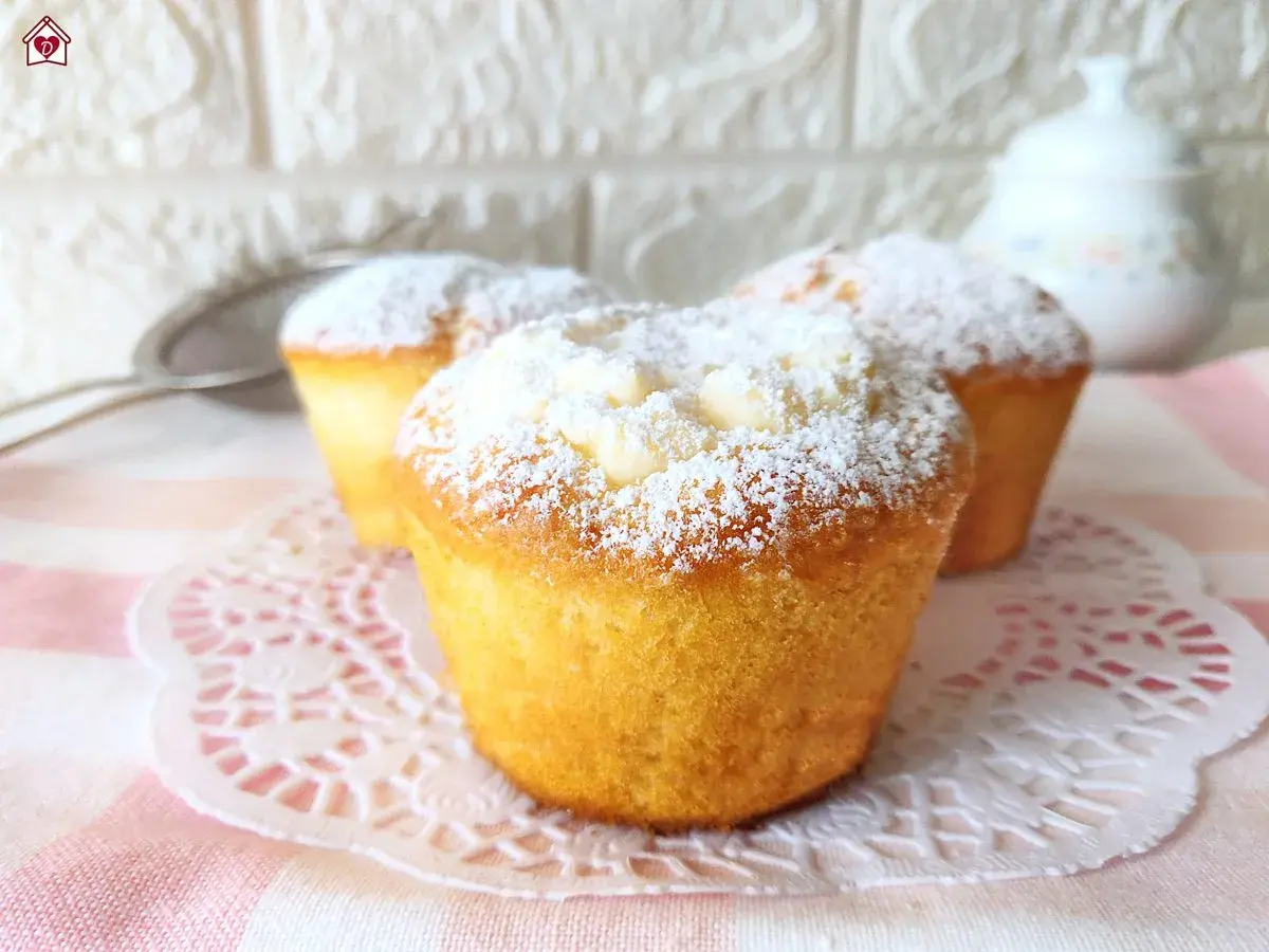 Tre muffin soffici, spolverati di zucchero a velo, perfetti per una ricetta muffin semplici e golosa.