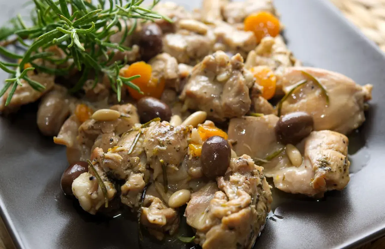 Coniglio alla ligure con olive, pinoli e rosmarino, un piatto saporito e profumato.