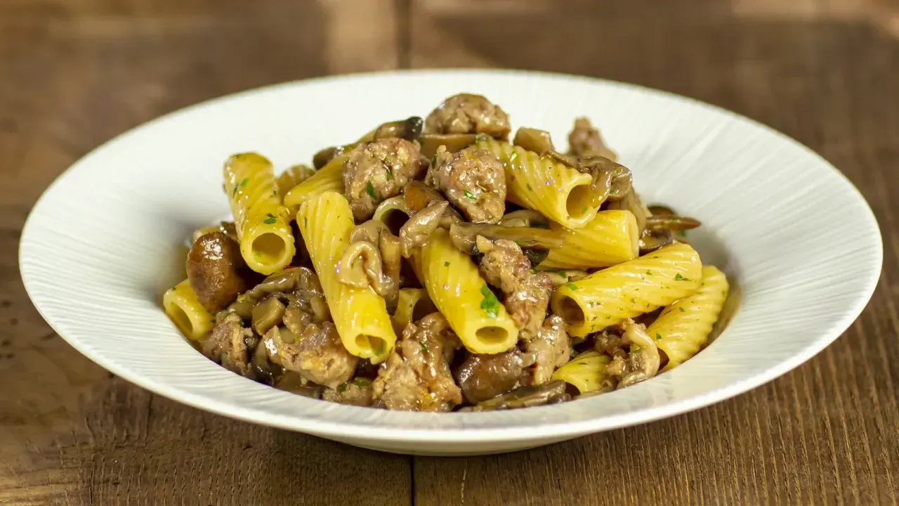 Piatto di pasta con funghi e salsiccia, un classico saporito.