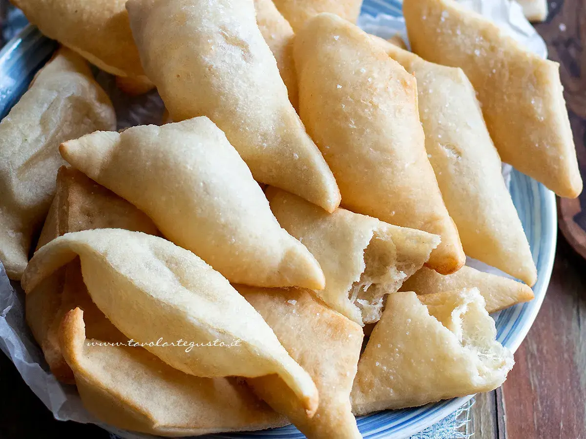 Un piatto colmo di gnocco fritto, dorato e croccante, pronto per essere gustato. La ricetta perfetta per un aperitivo sfizioso.