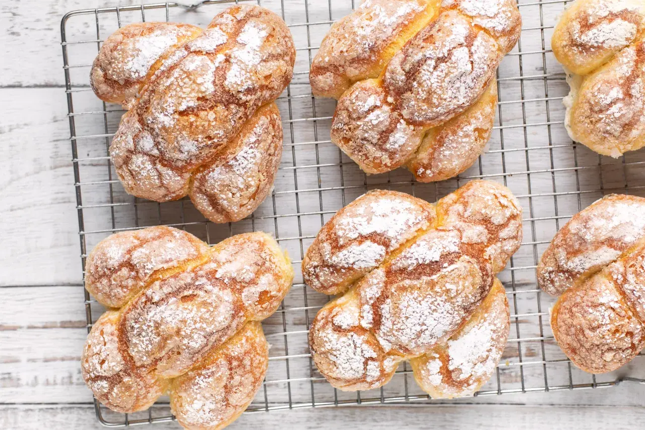 Colomba pasquale facile e veloce, dorata e cosparsa di zucchero a velo, raffreddata su una griglia.
