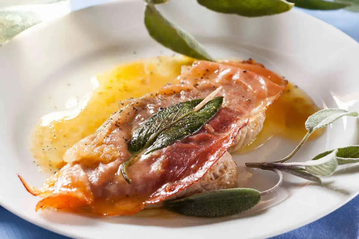 Saltimbocca alla romana ricetta: fettina di vitello con prosciutto crudo e salvia, bagnata da un sugo dorato.