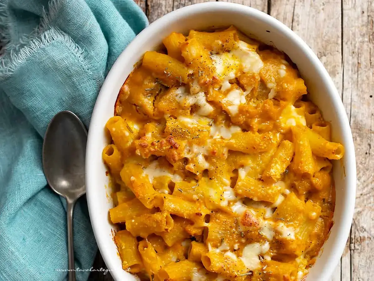 Piatto invitante di pasta con la zucca, gratinata al forno con formaggio filante e erbe aromatiche.
