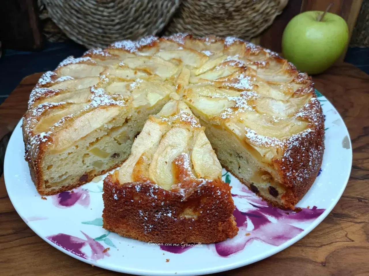 Una fetta di torta di mele soffice e profumata, cosparsa di zucchero a velo, pronta per essere gustata.