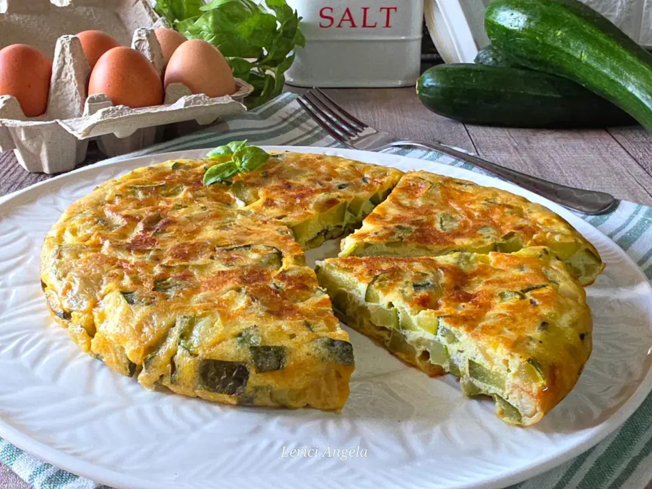 Una gustosa frittata di zucchine, dorata e soffice, con ingredienti freschi come uova e basilico.