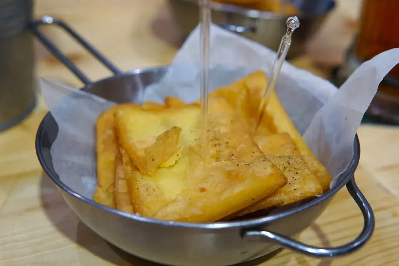 Un cestino di pane e panelle dorate, croccanti e appena fritte, pronte per essere gustate.