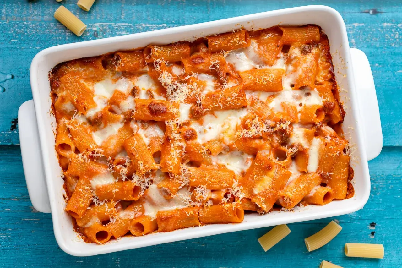 Un invitante piatto di pasta al forno, con rigatoni conditi con sugo rosso e abbondante formaggio fuso, pronto per essere gustato.