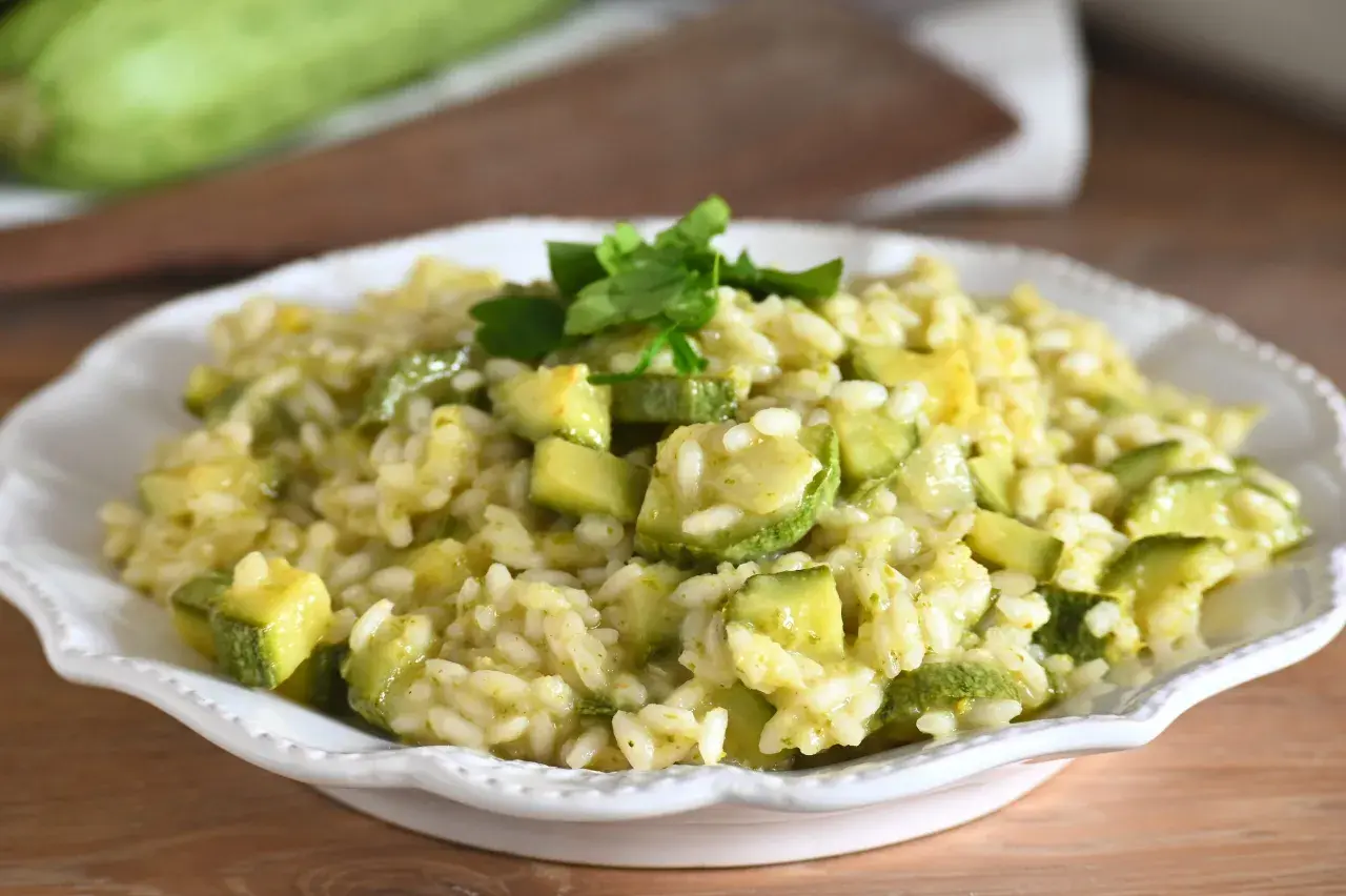 Un cremoso risotto con zucchine, guarnito con prezzemolo fresco, pronto per essere gustato.
