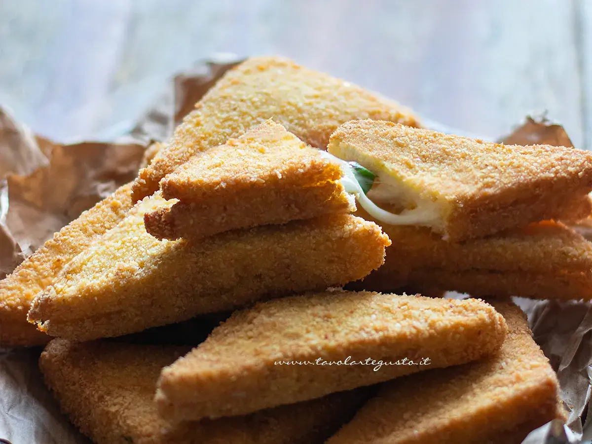 Mozzarella in carrozza dorate e croccanti, con il formaggio filante che fuoriesce da una fetta.