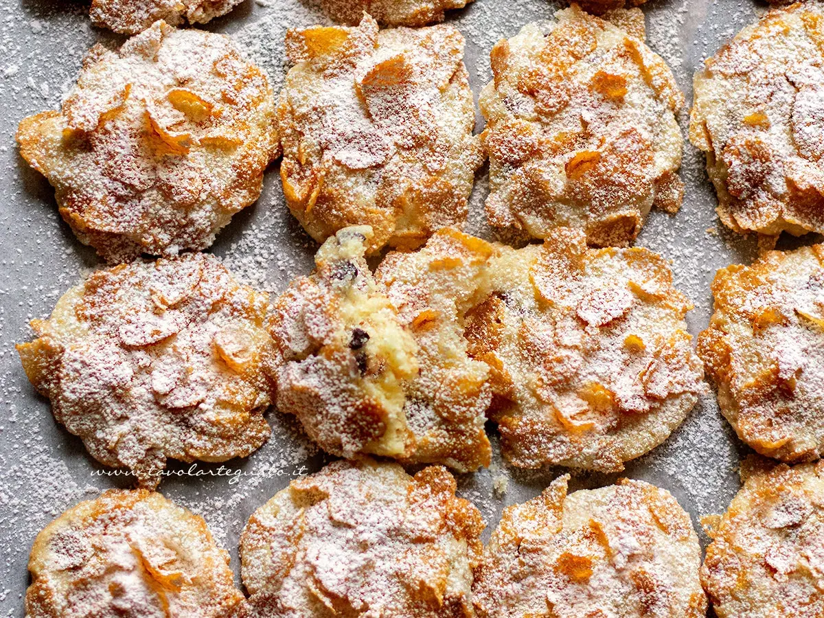 Biscotti croccanti, simili a rose del deserto, ricoperti di zucchero a velo e fiocchi di mais.