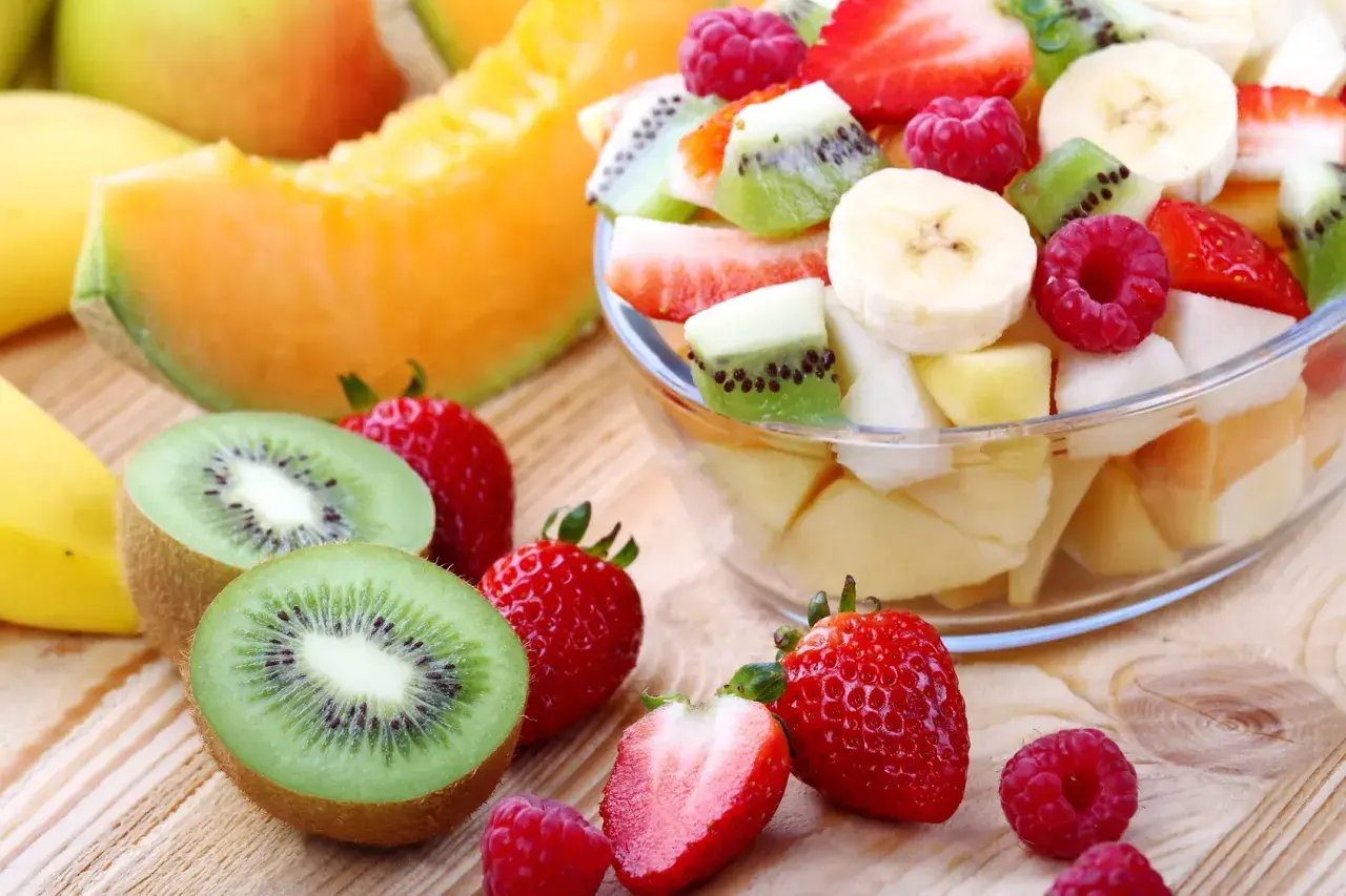 Una fresca macedonia di frutta, con fragole, kiwi, banane e melone, pronta per essere gustata.