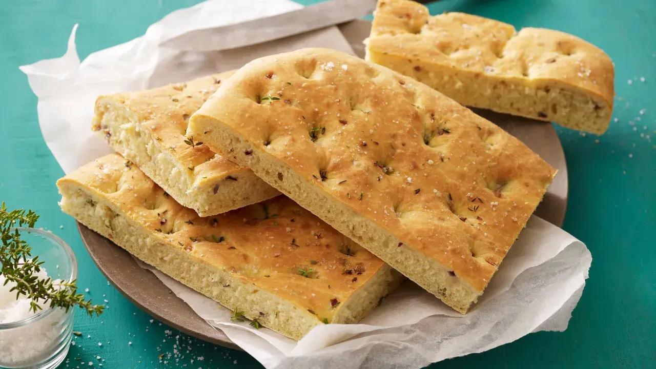 Focaccia con lievito istantaneo, soffice e dorata, condita con erbe aromatiche e sale grosso. Perfetta per un aperitivo veloce.