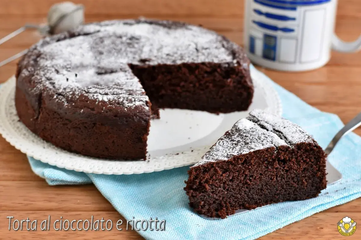 Torta al cioccolato e ricotta, soffice e golosa, spolverata di zucchero a velo. Una fetta invitante attende di essere gustata.