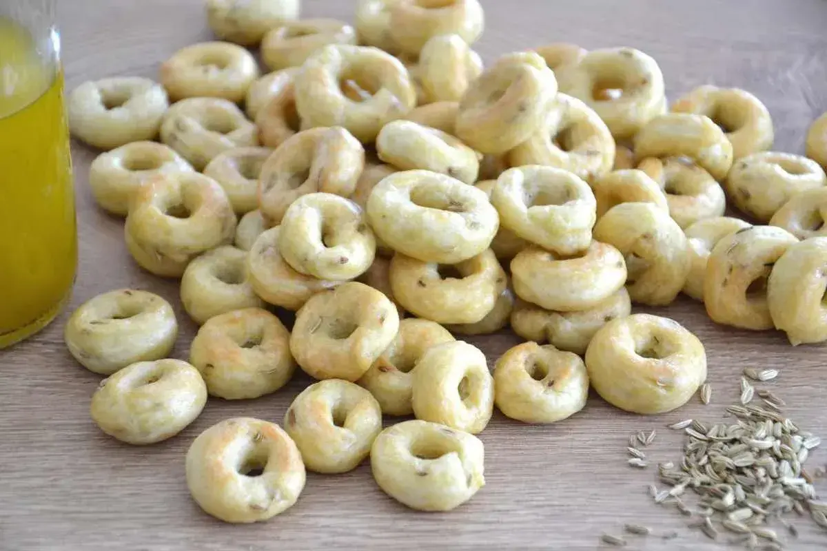 Taralli pugliesi ricetta originale: tanti piccoli anelli dorati, croccanti e profumati, pronti per essere gustati.