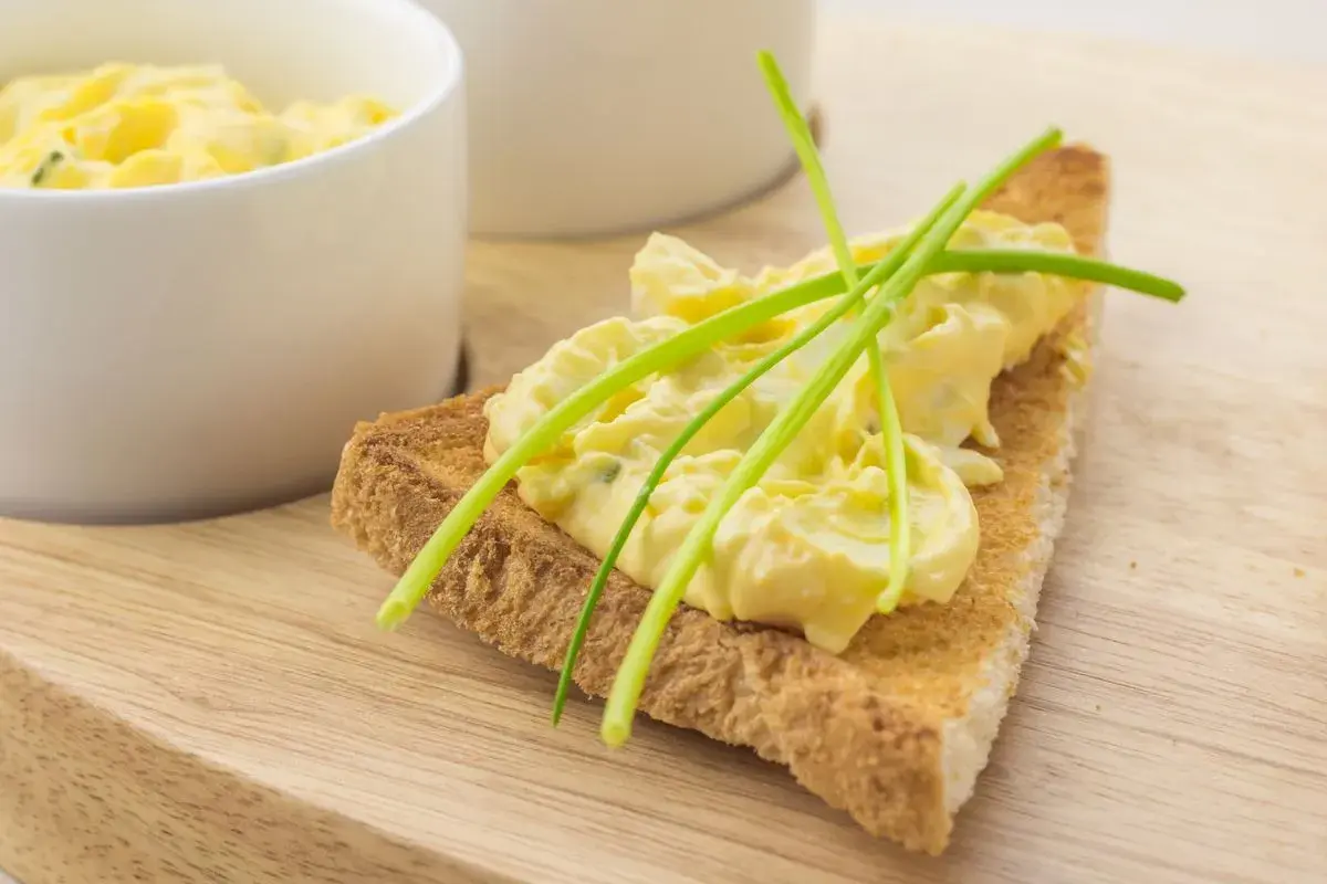 Fetta di pane tostato con salsa bolzanina ricetta, guarnita con erba cipollina. Cremosa e invitante, perfetta per un aperitivo.
