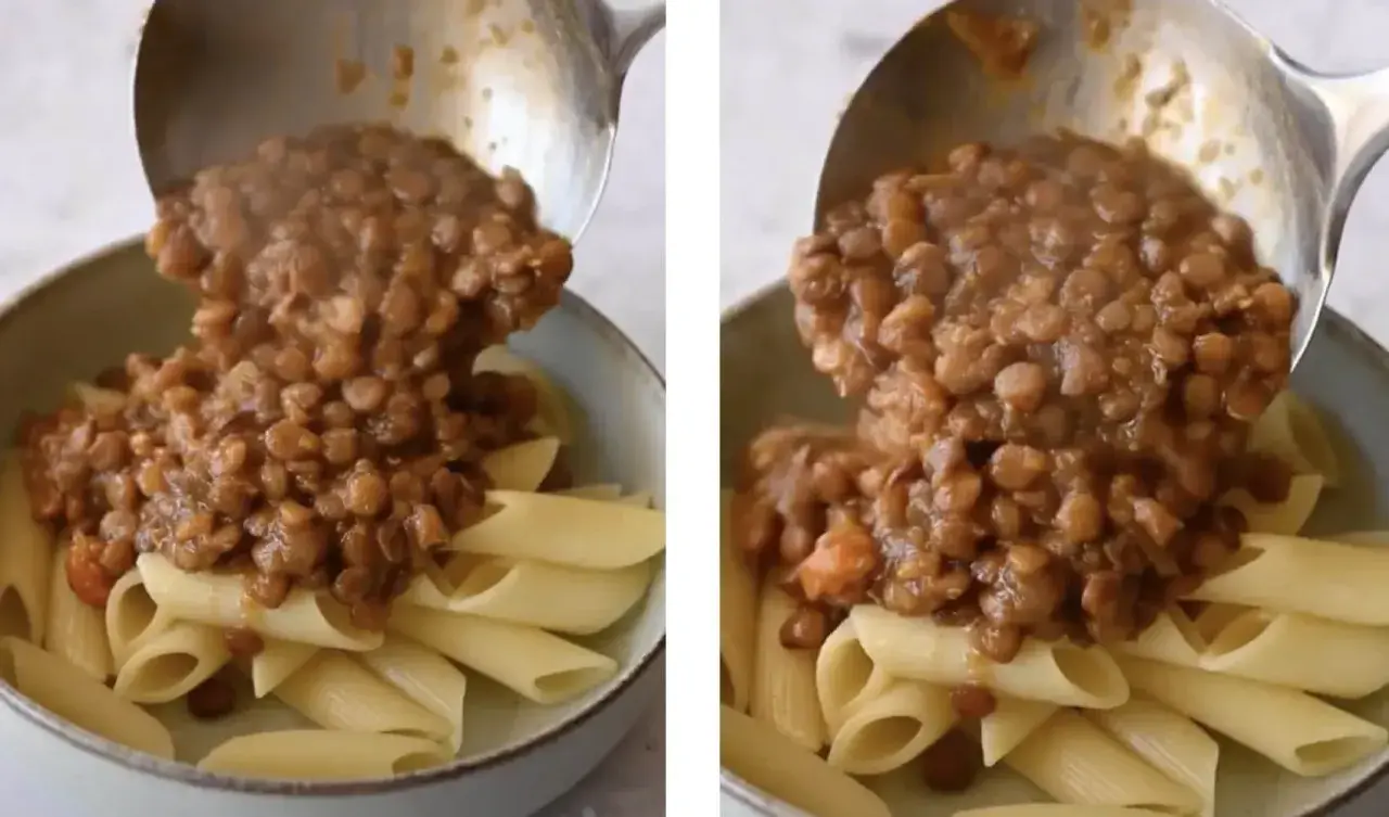 Un mestolo versa un saporito ragù di lenticchie su penne al dente. Un piatto vegetariano invitante e nutriente.