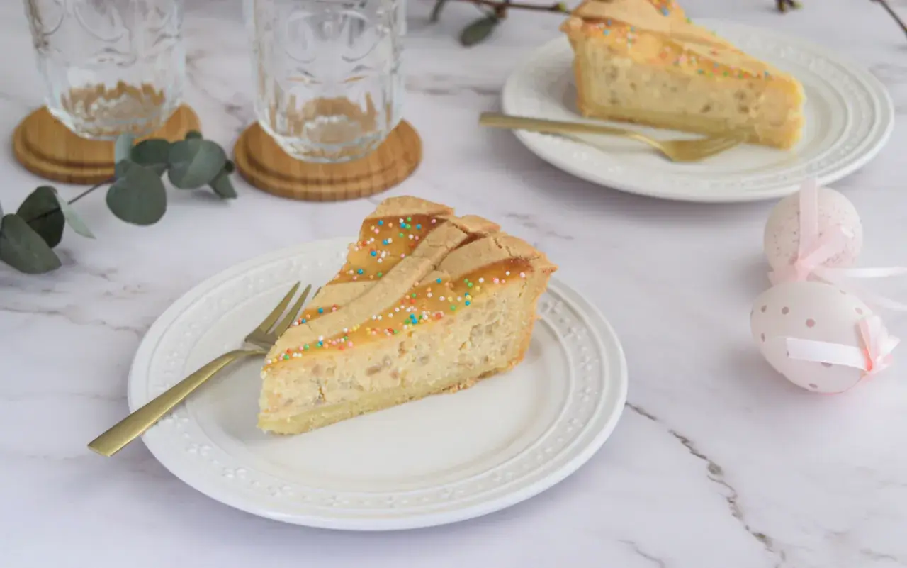 Fetta di pastiera napoletana, dolce tradizionale con grano cotto e ricotta, decorata con confettini colorati.