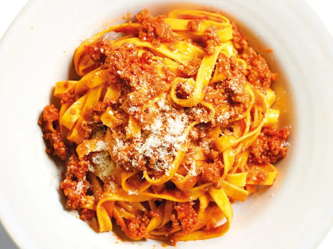 Un piatto invitante di tagliatelle al rag&ugrave;, condite con abbondante sugo di carne e una spolverata di parmigiano.