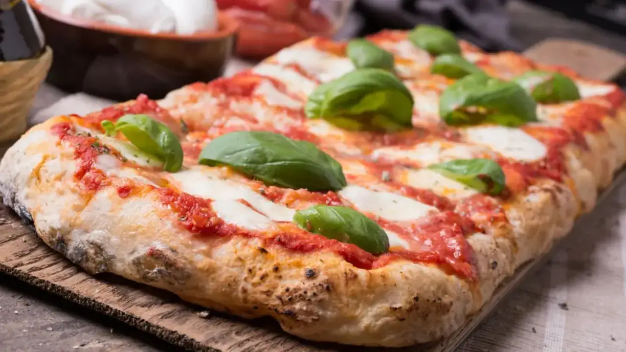 Pizza senza glutine, croccante e saporita, con pomodoro, mozzarella filante e basilico fresco. Un piacere per tutti i palati.
