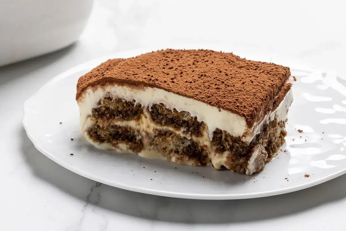 Una fetta di tiramis&ugrave;, con strati di savoiardi inzuppati nel caff&egrave; e crema al mascarpone, spolverata di cacao. Ecco come si fa il tiramis&ugrave;!