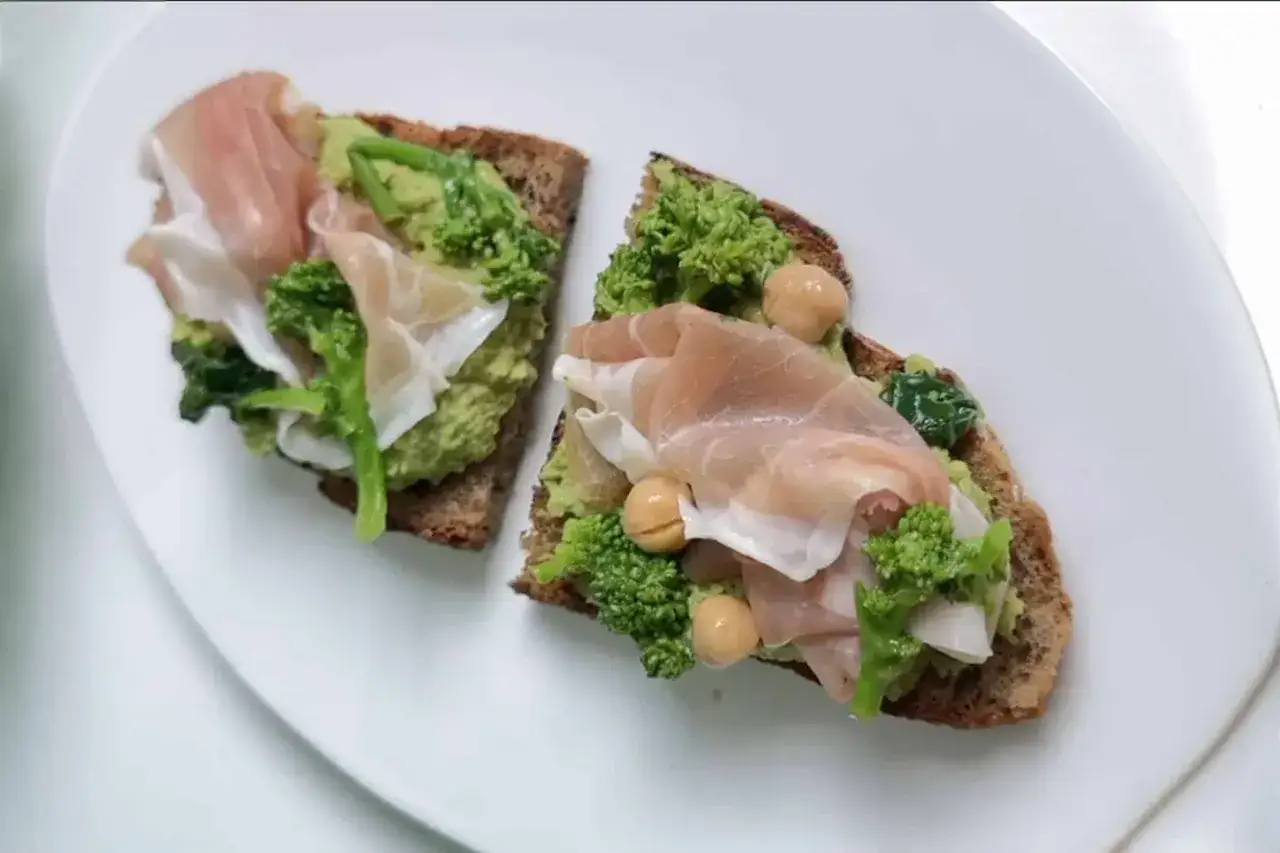 Bruschette con crema di ceci, broccoli, prosciutto crudo e spinacini. Un piatto leggero e gustoso.