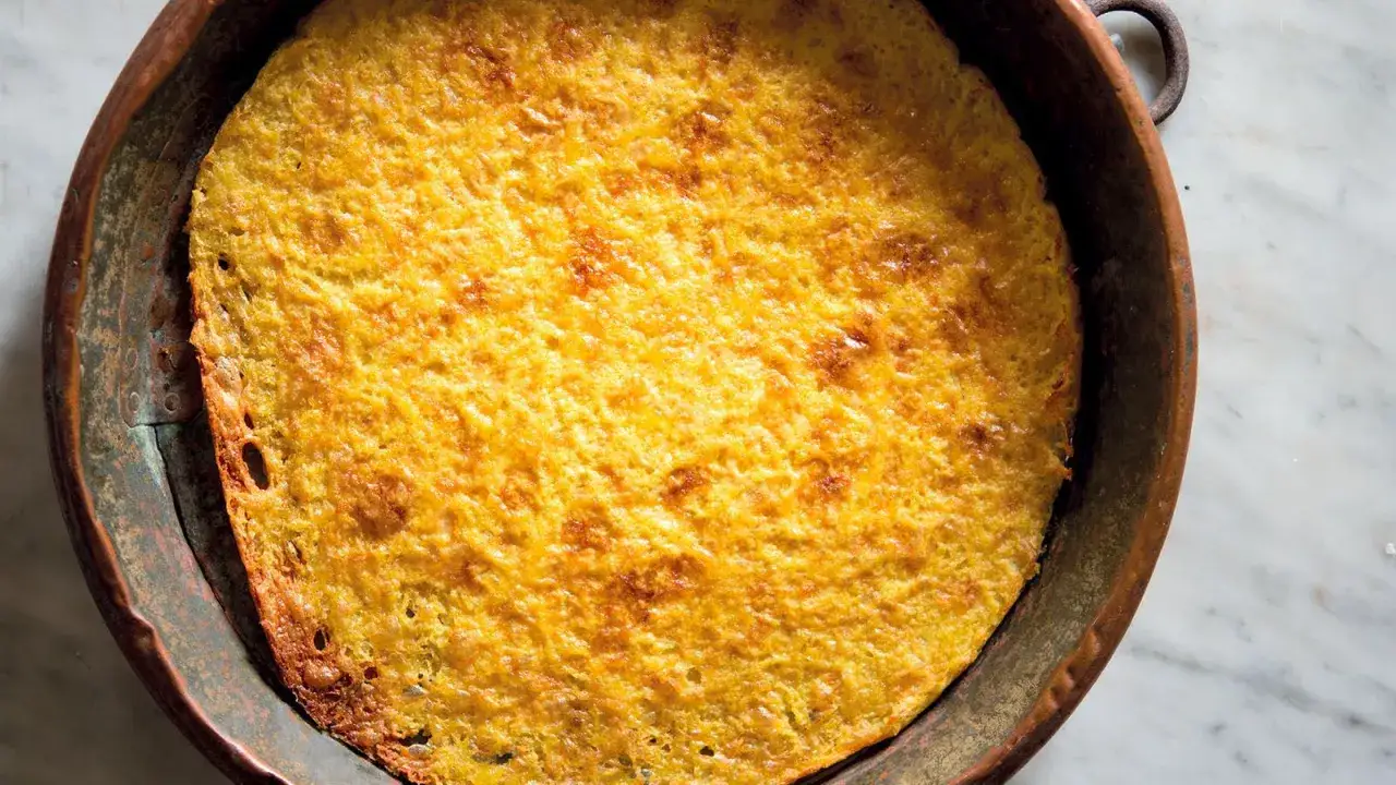 Farinata di ceci dorata e croccante, appena sfornata in una tradizionale teglia di rame.