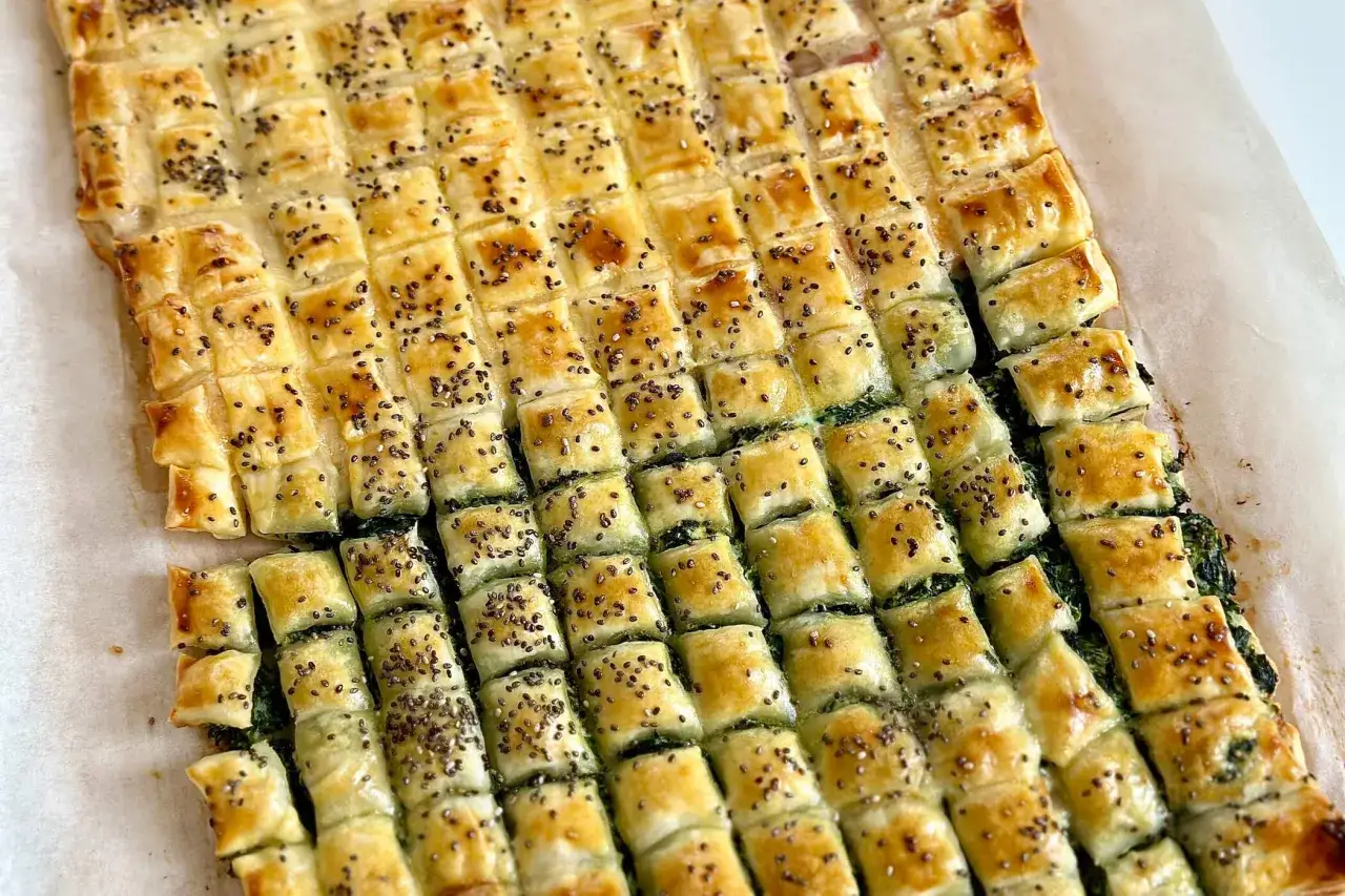 Salatini con pasta sfoglia ripieni di spinaci, dorati e cosparsi di semi di chia.