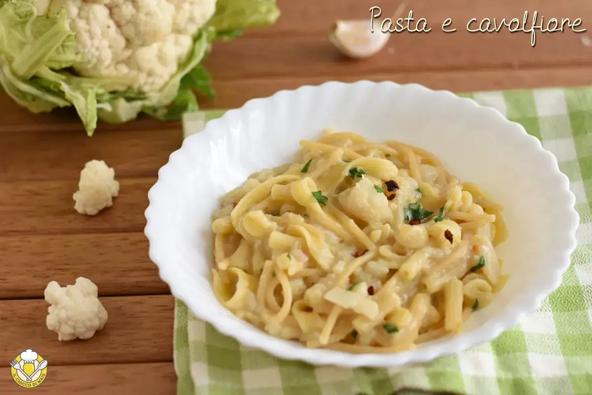 Un piatto cremoso di pasta e cavolfiore, guarnito con prezzemolo fresco e peperoncino.