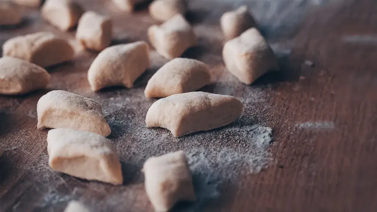 Gnocchi fatti in casa, ancora crudi e infarinati, pronti per essere cotti e gustati.