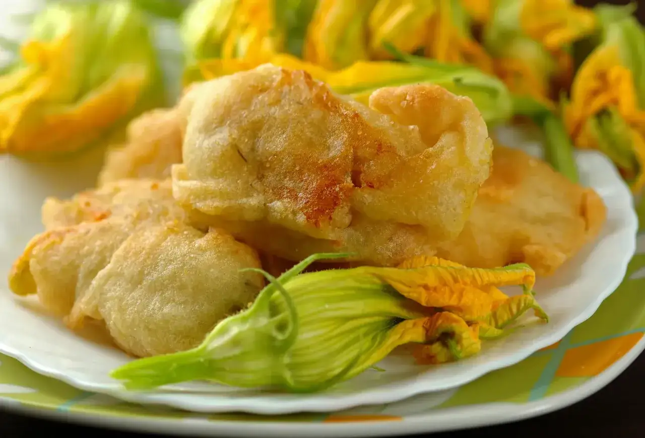 Fiori di zucca in pastella dorati e croccanti, un antipasto irresistibile.