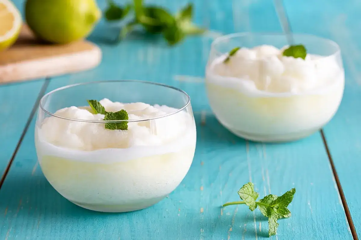 Sorbetto al limone Bimby, fresco e cremoso, guarnito con menta. Perfetto per l'estate.