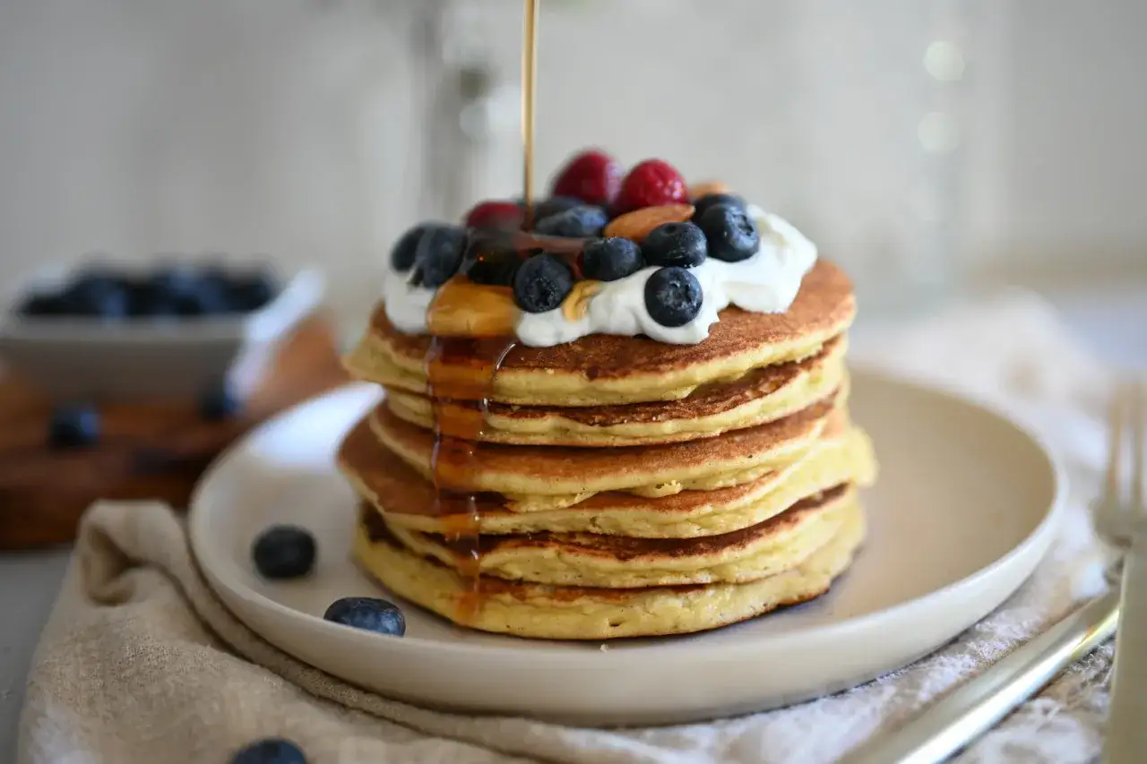 Pancake allo yogurt con sciroppo d'acero, mirtilli, lamponi e mandorle. Una delizia per iniziare la giornata!