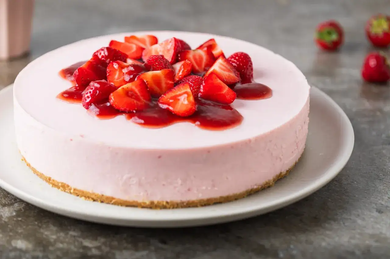 Delizioso dolce rosa con fragole fresche e salsa, un'esplosione di sapori estivi.