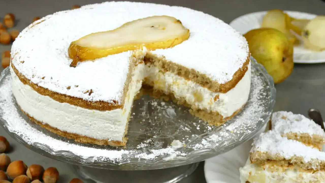 Torta ricotta e pere soffice, con crema vellutata e una fetta di pera candita in cima. Un dolce invitante.