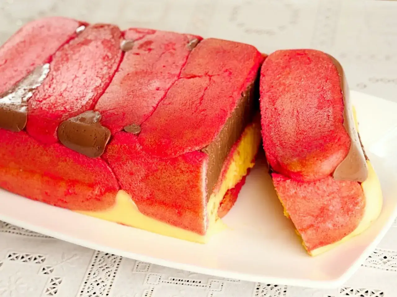 Zuppa inglese ricetta originale emiliana: strati di pan di Spagna rosa, crema al cioccolato e crema pasticcera, decorata con gocce di cioccolato.