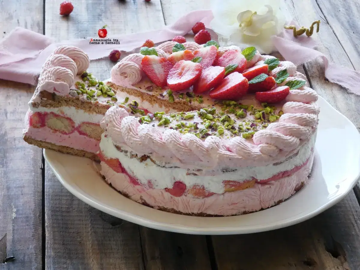Delizioso semifreddo alle fragole, stratificato con crema, biscotti e guarnito con fragole fresche e pistacchi.