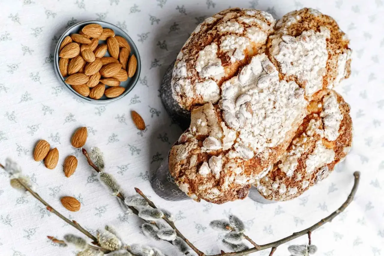 Colomba pasquale facile e veloce, con mandorle e glassa croccante, accanto a rametti di salice.