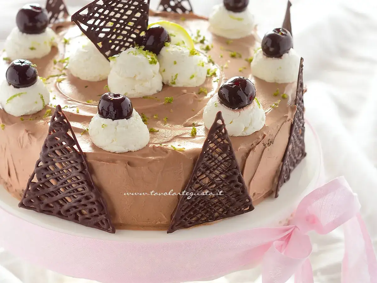 Deliziosa torta foresta nera con panna montata, ciliegie e decorazioni di cioccolato.