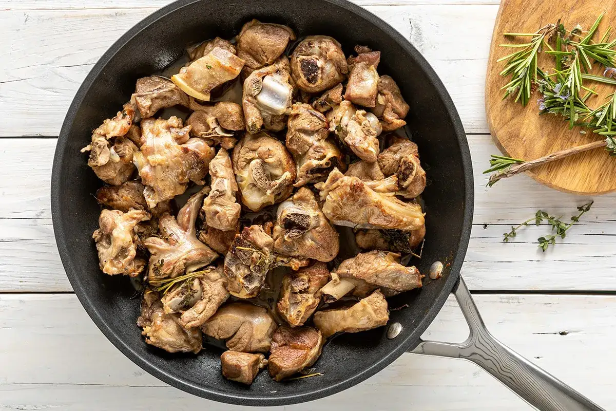 Succulento agnello in padella, cotto a puntino con erbe aromatiche. Un piatto saporito pronto per essere gustato.