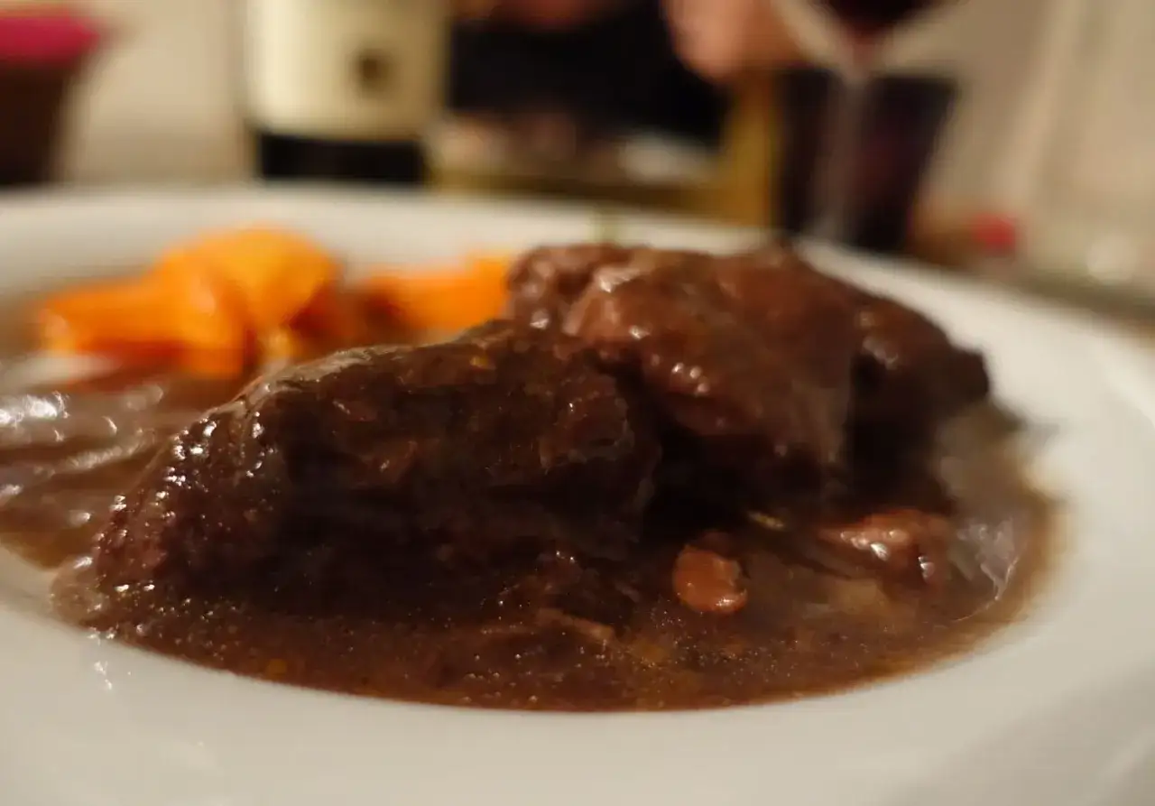 Un succulento brasato al barolo, tenero e saporito, accompagnato da carote arancioni.
